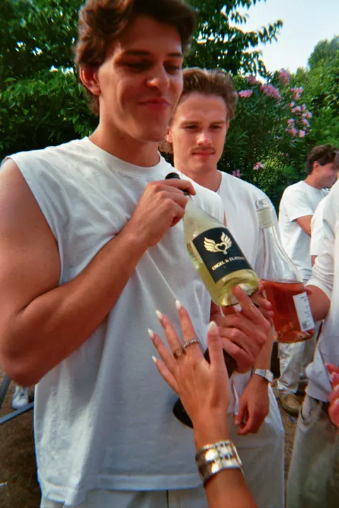 Zwei Freunde in Weiß mit einer Flasche HELL