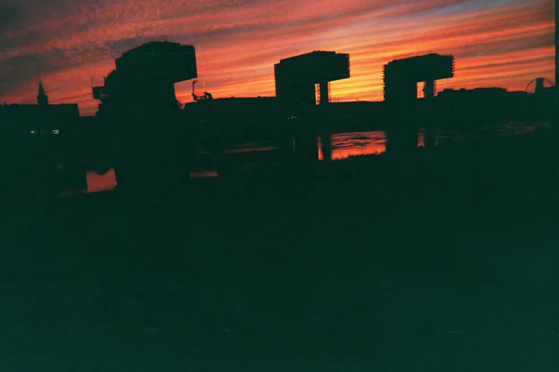 Sonnenuntergang über dem Rhein, die Kranhäuser in Köln als Silhouette